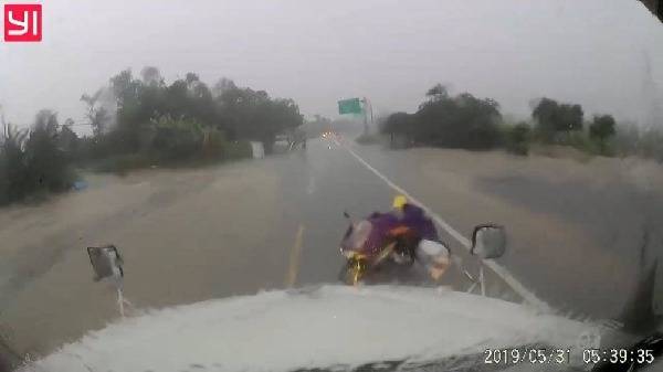 Clip: Khoảnh khắc người phụ nữ dắt xe máy lao thẳng vào đầu container khi trời mưa to