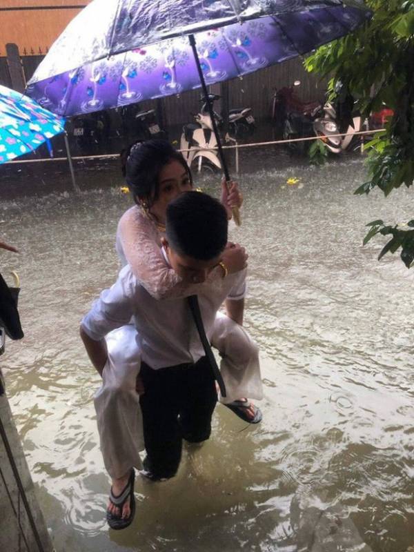‘Em gái mưa’ phiên bản lũ lụt: Bức ảnh chú rể cõng cô dâu gây sốt MXH