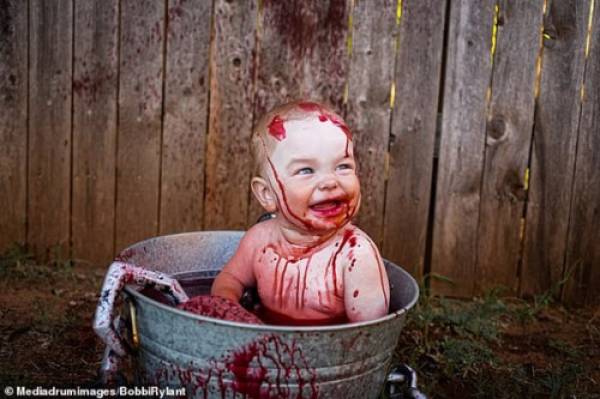 Cậu con trai Kamden mới 10 tháng tuổi được ngồi trong một chậu sắt tràn ngập phẩm màu và tạo dáng.