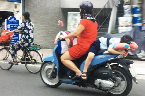 Cộng đồng mạng bức xúc vì hình ảnh người phụ nữ buộc đứa trẻ sau xe máy ở TP.HCM