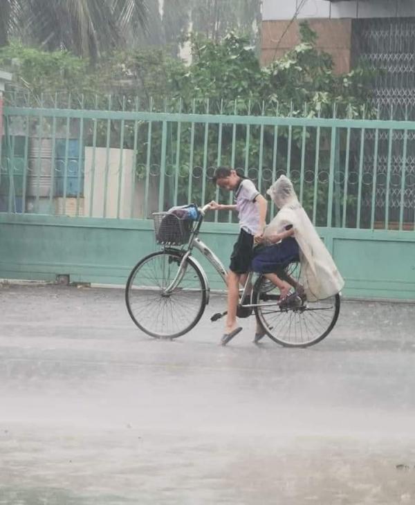 Ấm lòng khoảnh khắc chị đội mưa đạp xe lai em mặc áo mưa: Cả thế giới cứ để chị lo