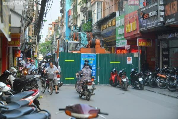 Ảnh: Rào tôn chắn gần hết lòng đường ở Hà Nội, dân khổ sở luồn lách đi qua