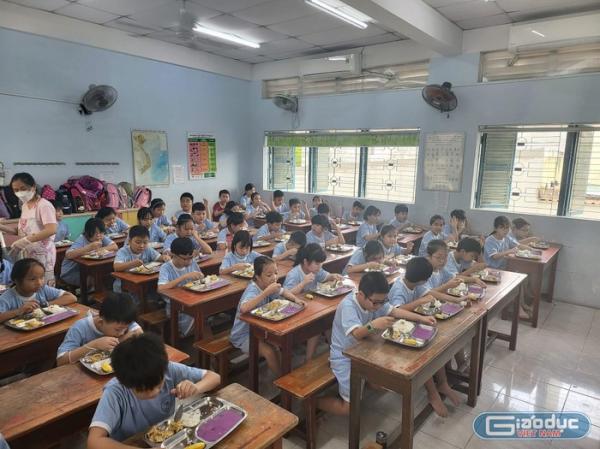 Bảo mẫu Tiểu học Nguyễn Thị Minh Khai sử dụng tay để chia đồ ăn cho học sinh